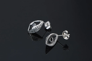 Macro shot of punk style steel earrings featuring black stone and textured scale pattern