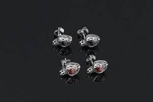 Detailed close-up of crown heart studs with red and black gems on black background