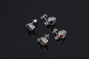 Detail of hollow crown and heart stud earrings set with red and black crystals