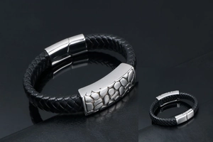 Close-up of woven leather bracelet featuring a silver pebble-textured magnetic clasp