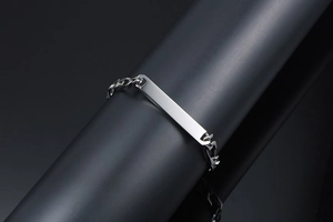 Gros plan d'un bracelet gourmette en acier inoxydable argenté sur support noir