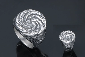 Close-up of vintage titanium steel ring featuring vortex texture and star engravings