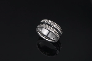 Detail of silver titanium steel ring with black stones and punk style chain texture