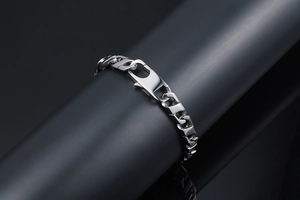 Gros plan d'un bracelet gourmette industriel en acier titane avec un grand fermoir mousqueton