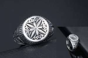 Macro detail of vintage titanium steel ring with star engraving and leaf patterns