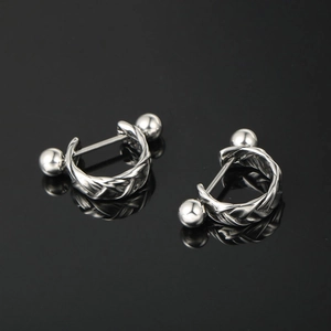 Western style silver braided twist ear studs with polished beads on black background