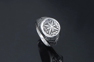 Macro detail of vintage stainless steel signet ring with engraved compass star