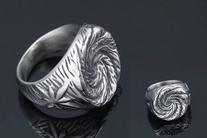 Macro view of men's titanium steel ring with vintage spiral texture and dark finish