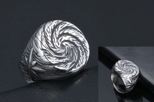 Detail view of punk titanium steel ring with vintage spiral pattern and textured finish