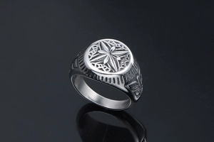 Macro shot of silver titanium steel ring featuring an engraved star and cutout patterns