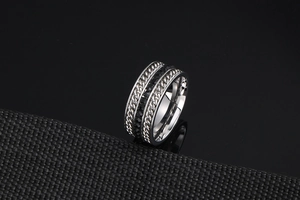 Detail of silver titanium steel ring featuring black zircon inlay and twisted chain texture