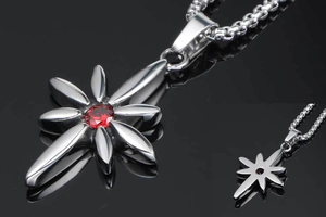 Close-up of silver punk star cross pendant with red gemstone on a bead chain
