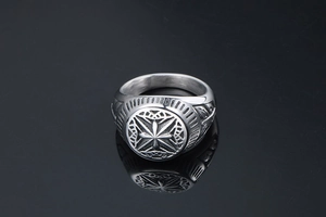 Macro shot of silver titanium steel ring with compass star engraving on black background