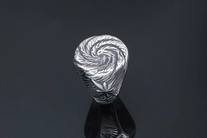 Close-up of vintage titanium steel ring with spiral embossed texture and star engraving