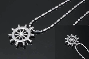 Detailed close-up of a silver ship wheel pendant with a center diamond on a bead chain