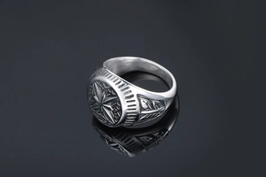 Close-up of vintage titanium steel ring featuring detailed star engraving and leaf patterns