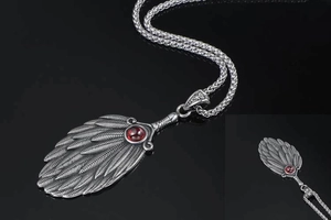 Detailed macro view of silver feather pendant with center ruby gemstone and twisted chain