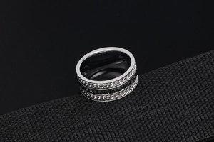 Close-up of men's titanium steel ring with black faceted stones and cuban link texture