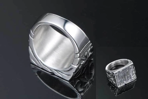 Macro detail of silver stainless steel ring showing abacus relief and brushed metal texture