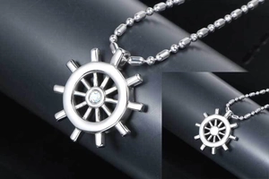 Close-up of polished nautical ship wheel pendant with sparkling center rhinestone and ball chain