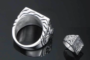 Macro detail of silver titanium steel signet ring with star engravings and smooth inner band