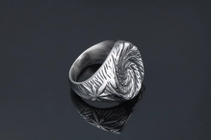 Detail of vintage punk titanium steel ring with spiral relief and maple leaf texture