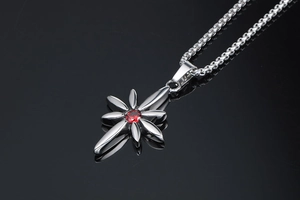 Close-up of punk style silver flower pendant with central red ruby on a box chain
