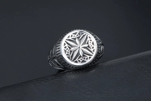 Detailed view of stainless steel signet ring with compass star relief on black leather
