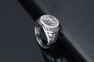 Macro shot of titanium steel signet ring with engraved star pattern and brushed metal finish