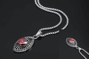 Close-up of vintage stainless steel teardrop necklace with red zircon and mesh detail