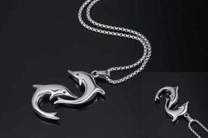 Close-up of polished silver titanium steel double dolphin pendant on box chain