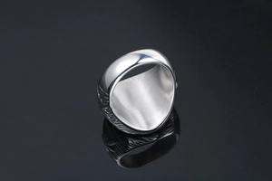 Macro shot of silver titanium steel ring with vintage carving and polished mirror surface