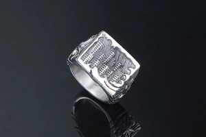 Detailed relief of city buildings on a vintage stainless steel punk ring with mirror reflection