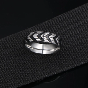 Men's titanium steel ring with black chevron tire tread pattern in industrial style