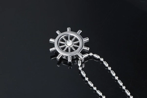 Detail of nautical rudder pendant with center zircon and silver ball chain
