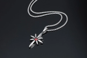 Macro detail of punk titanium steel star pendant with a faceted red ruby zircon stone