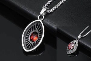 Macro shot of retro stainless steel pendant with red gemstone and hollow ray design