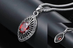 Macro view of water drop ruby pendant with radiating cut-out patterns and wheat chain