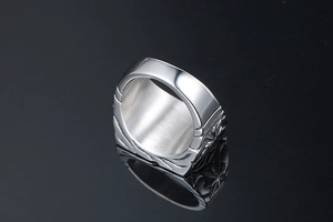 Detailed side view of silver titanium steel signet ring with star engravings and brushed finish