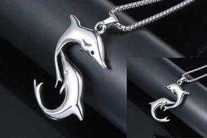 Detailed view of polished stainless steel double dolphin pendant with a box chain