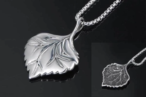Close-up of leaf pendant necklace showing detailed vein texture and matte silver finish
