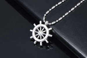 Macro shot of silver steering wheel pendant with sparkling diamond center and bead chain