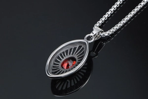 Close-up of teardrop stainless steel pendant with red gemstone and textured back detail