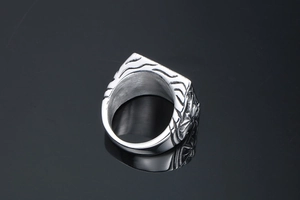 Macro shot of silver titanium steel ring featuring engraved geometric sunburst patterns