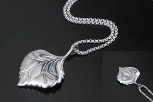 Macro shot of silver leaf pendant showing detailed vein texture on a sleek box chain
