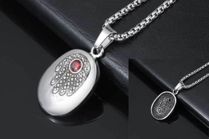 Macro shot of Hamsa hand pendant with red gemstone and textured back on titanium steel