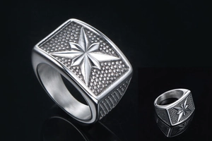 Macro detail of men's stainless steel signet ring with eight-pointed star and vintage texture