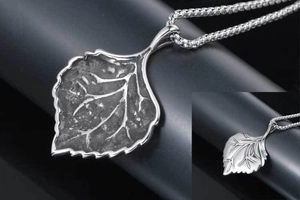 Macro detail of the silver leaf pendant showing antique texture and engraved leaf veins