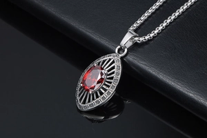 Close-up of vintage ruby pendant necklace with intricate silver openwork and small crystals