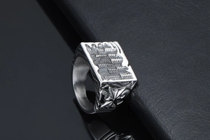 Close-up of vintage stainless steel signet ring with detailed cathedral engraving